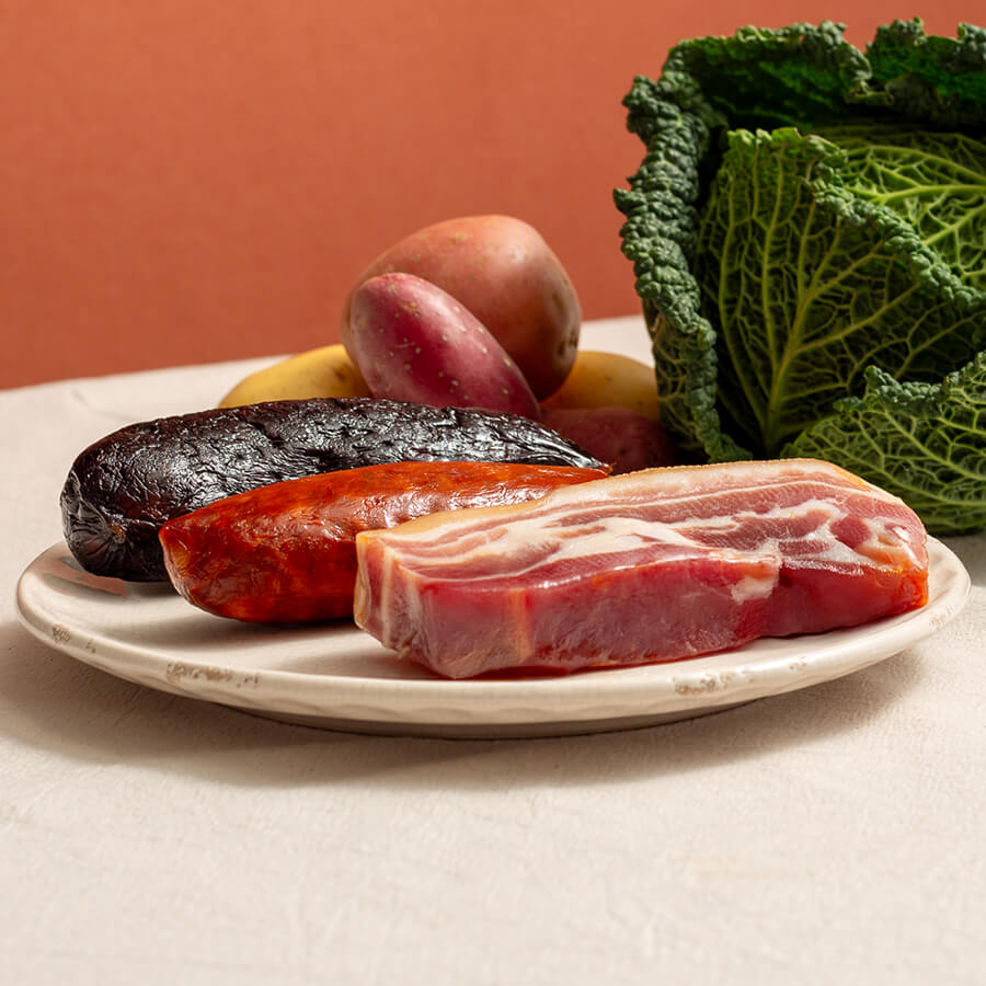 compago, asturian meat for fabada, panceta, pancetta, chorizo, black pudding in a plate with a savoy cabbage and heirloom potatoes