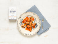 A plate with mussels in a tomato-based marinade on a white background.