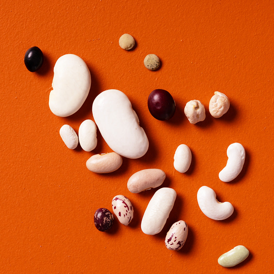Assorted rare dried beans on an orange background