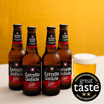 Four bottles of Estrella Galicia beer with a glass of beer and 'Great Taste' award logo on a yellow background.