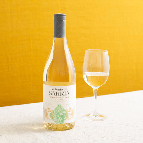 A bottle of white wine and a glass