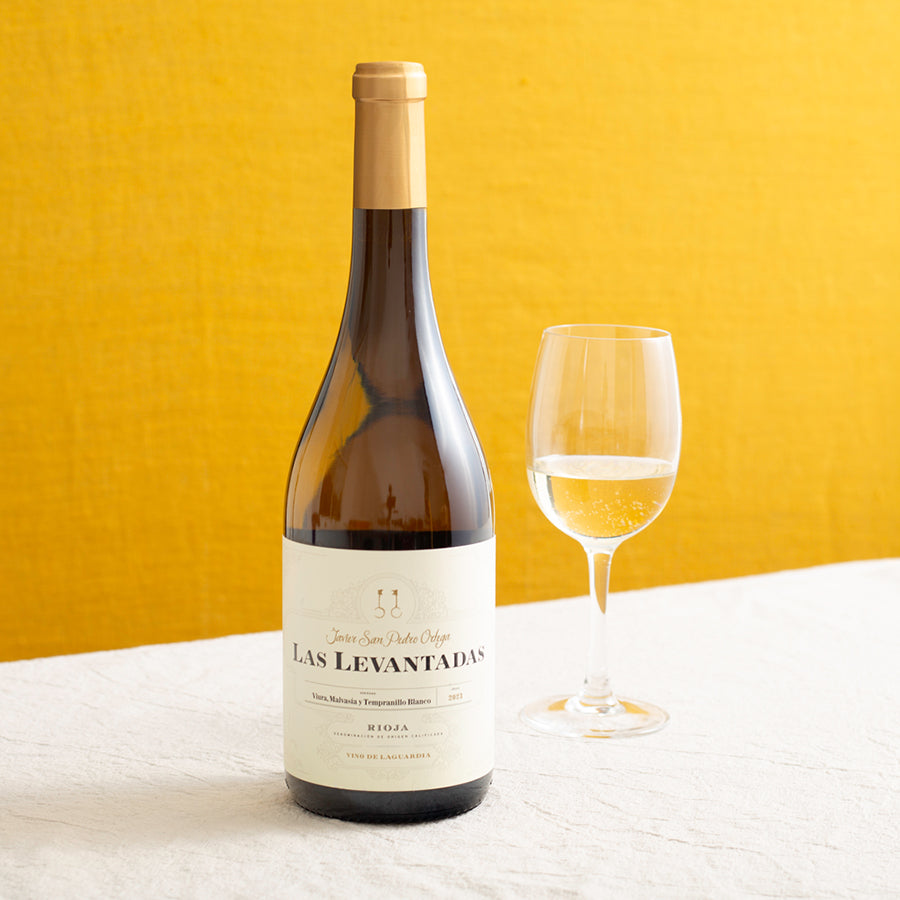 A bottle of white wine and a glass