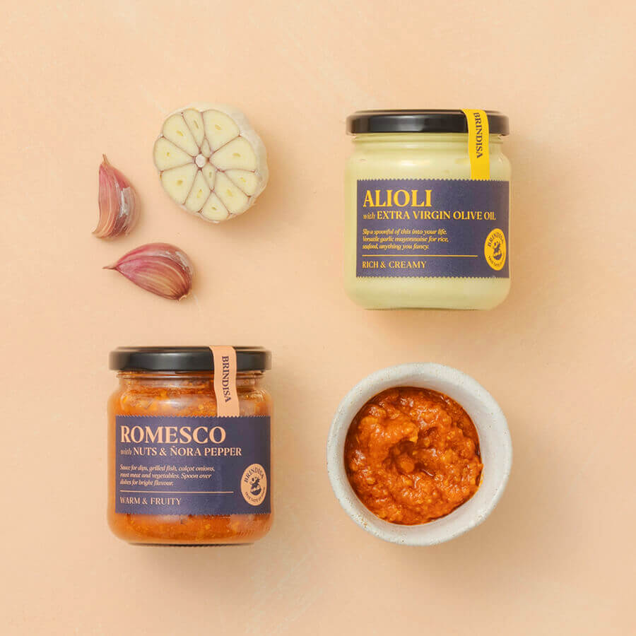 a jar of Romesco and a jar of Alioli sauce on a beige background