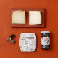 A flat-lay of Spanish cheeses, pickled figs and date and almond cake. 