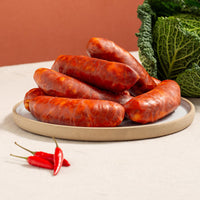 hot cooking chorizo in a plate, three chillies and a savoy cabbage