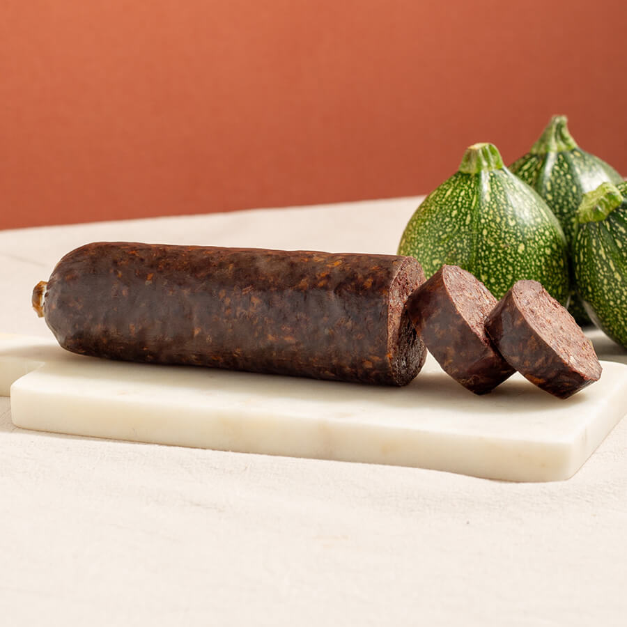 morcilla de burgos, black pudding with rice, whole and two slices, and three moon courgettes 