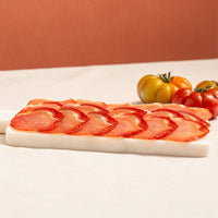 lomo (cured loin) slices in a tray and tomatoes