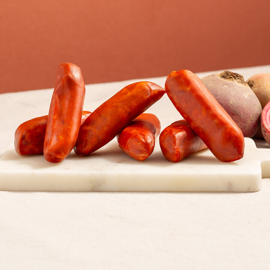 chorizo sausages on a marble board, vibrant red and two candy beetroot 