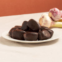 mini morcilla black pudding in a plate with two garlic heads