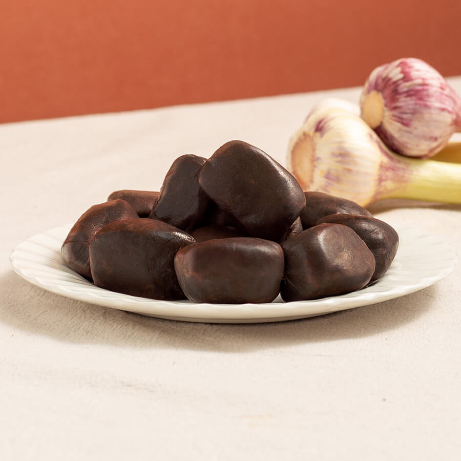 mini morcilla black pudding in a plate with two garlic heads