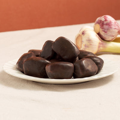 mini morcilla black pudding in a plate with two garlic heads