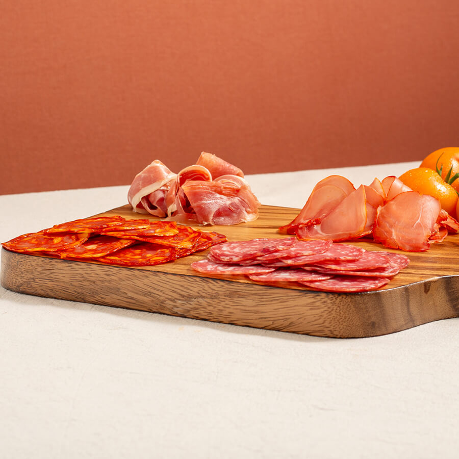 a charcuterie board selection, salchichon, chorizo, lomo (loin) and serrano ham. Yellow tomatoes at the back