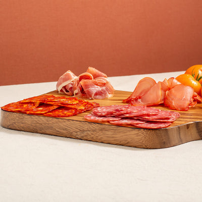 a charcuterie board selection, salchichon, chorizo, lomo (loin) and serrano ham. Yellow tomatoes at the back
