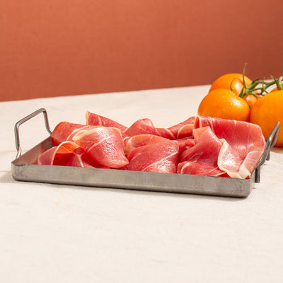 serrano ham slices in a tray and tomatoes