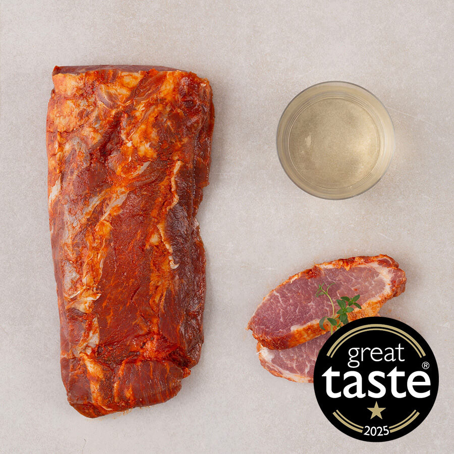 Raw marinated iberico pork loin with sliced pieces and 'Great Taste' award logo on a light background