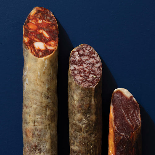 Three different types of cured meats on a dark blue background