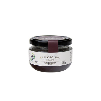 A 100g glass jar of La Masrojana Black Olive Paste, featuring a white label with olive illustrations and a dark purple accent band, sealed with a black lid on a white background.