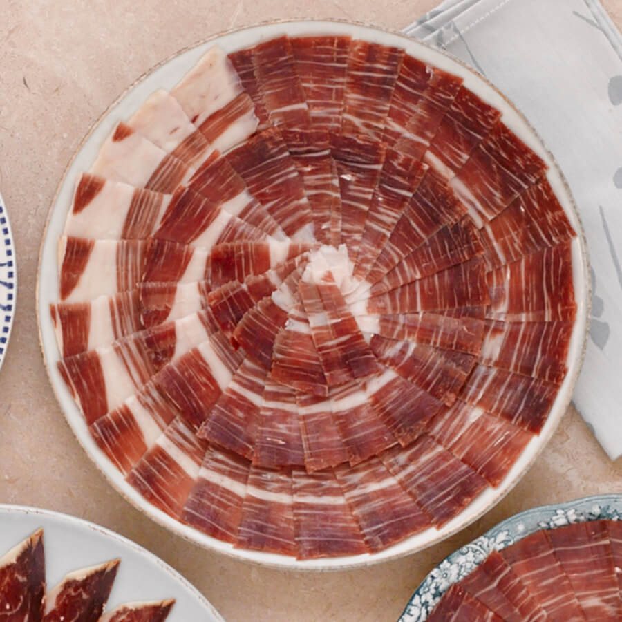 hand carved ham in a circular pattern on a plate.