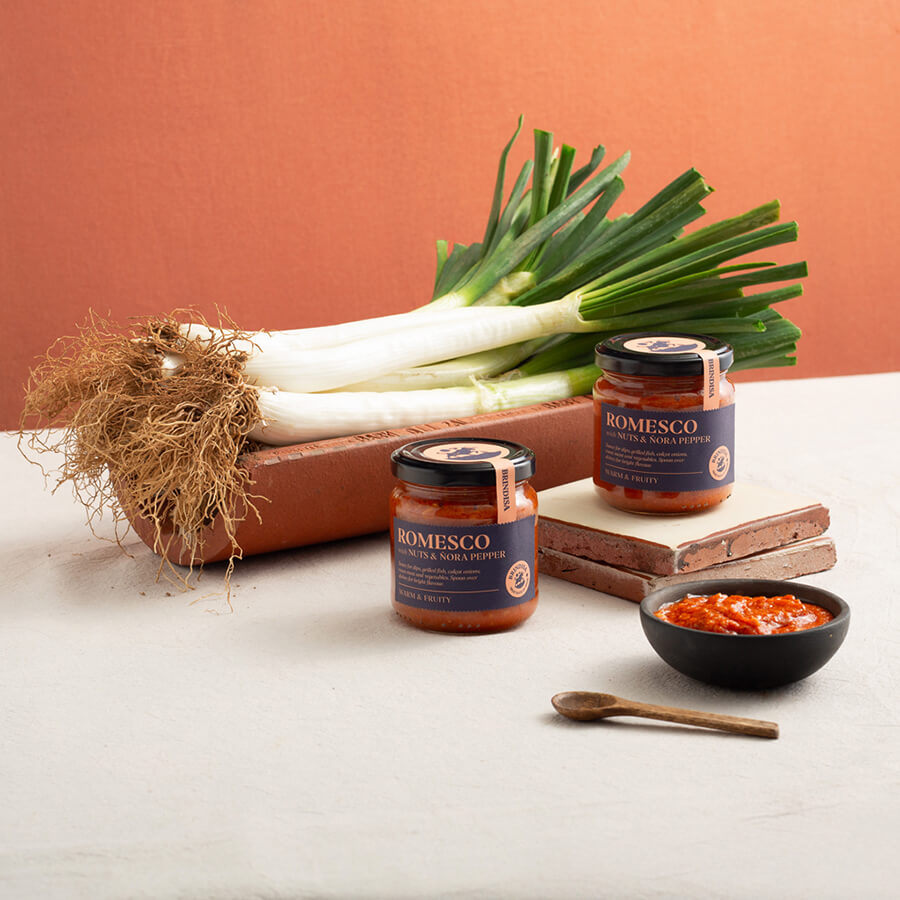 Calcots and two jars of Romesco Sauce and a bit served in a bowl Brindisa Spanish Foods