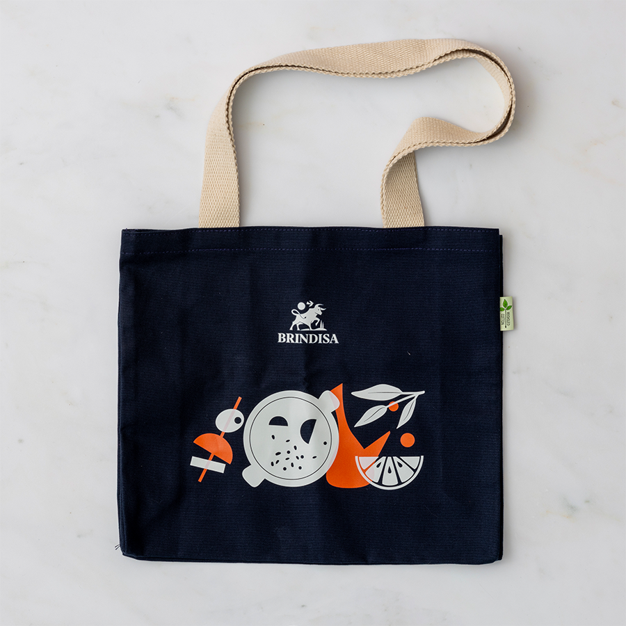 Blue Brindisa-branded tote bag on a clear marble background