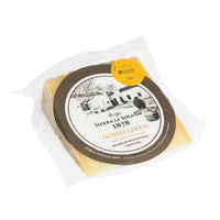 A packaged wedge of Sierra La Solana Truffle Cheese on a clean white background. The cheese is sealed in a clear plastic bag with a large round label featuring the brand name and a yellow circular seal.