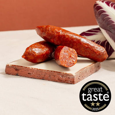 Asturian smoked chorizos on a cutting board with a 'Great Taste' award logo in the corner.