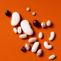 Assorted rare dried beans on an orange background