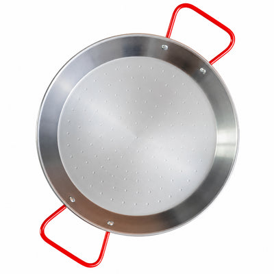 A steel paella pan with red handles on a white background