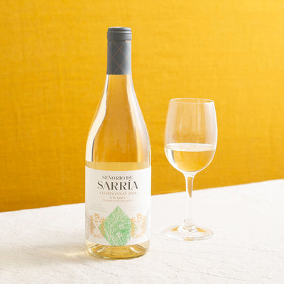 A bottle of white wine and a glass