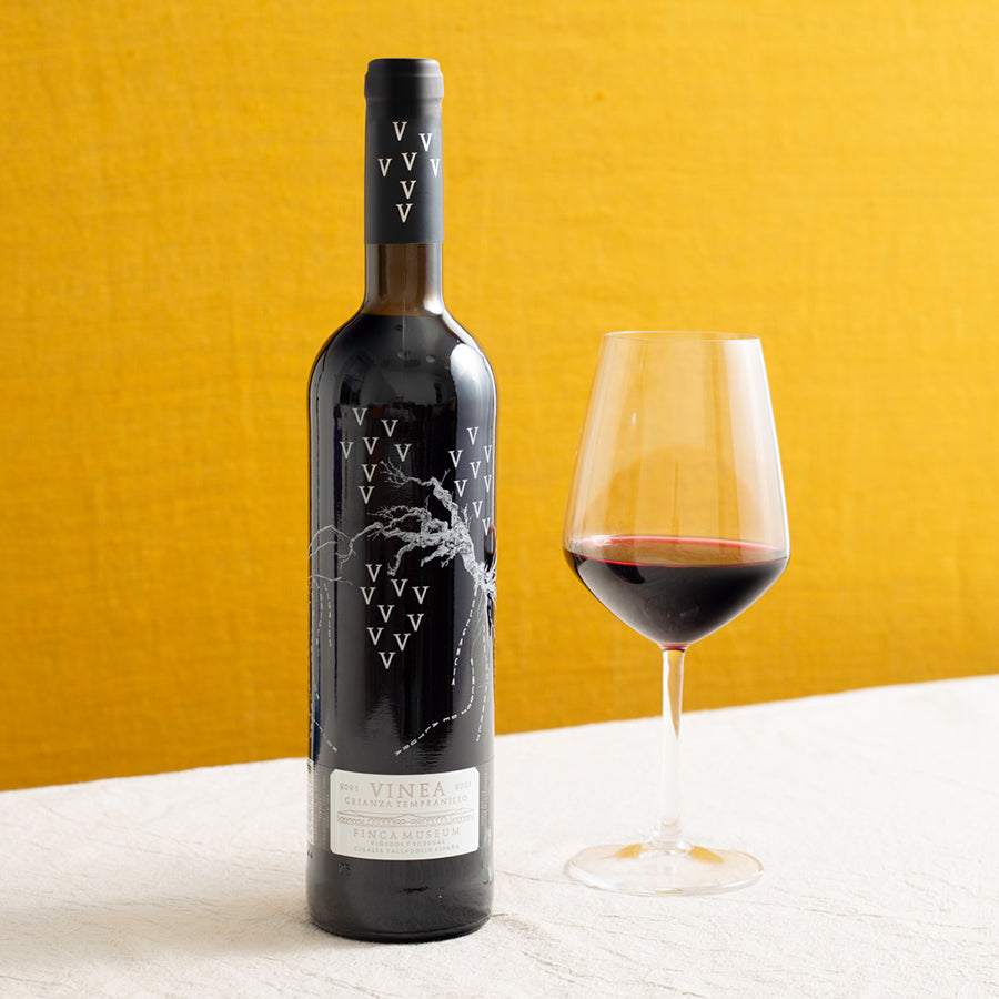 A bottle of red wine and a glass