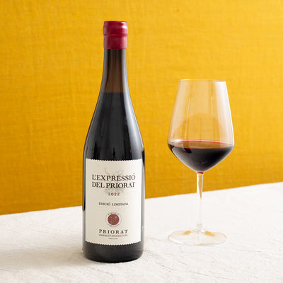 A bottle of red wine and a glass