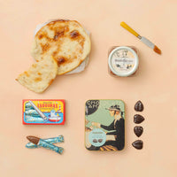 Assorted food items, including Andalusian tortas, chocolate, and membrillo, on a beige background