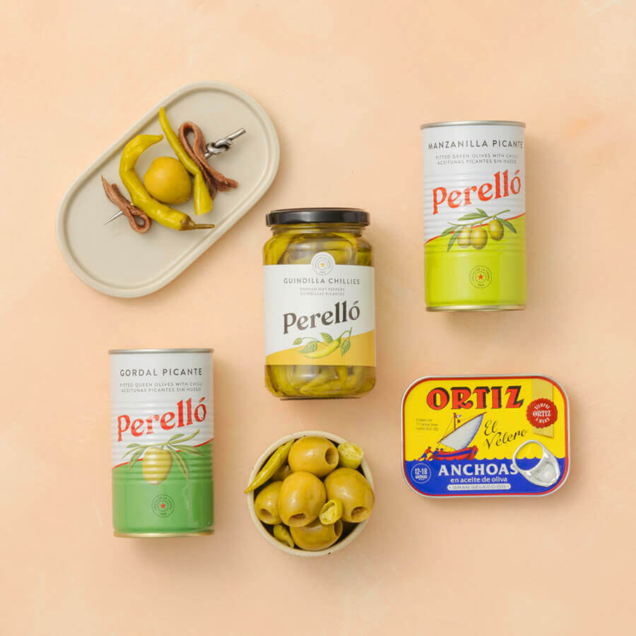 Collection of Perello and Ortiz olive products on a beige background