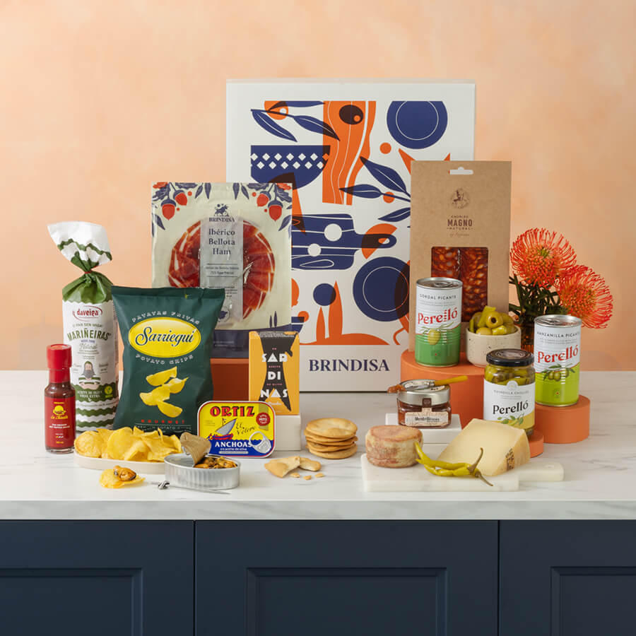 Assorted food products including cheese, chips, and drinks on a table with decorative elements.