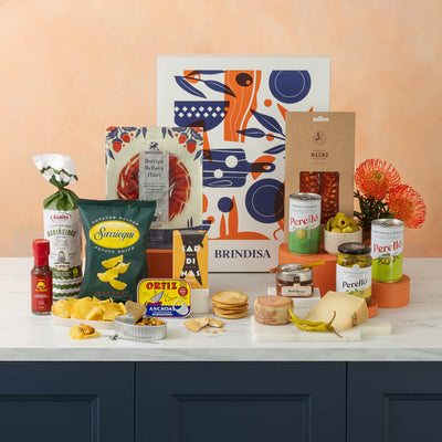 Assorted food products including cheese, chips, and drinks on a table with decorative elements.