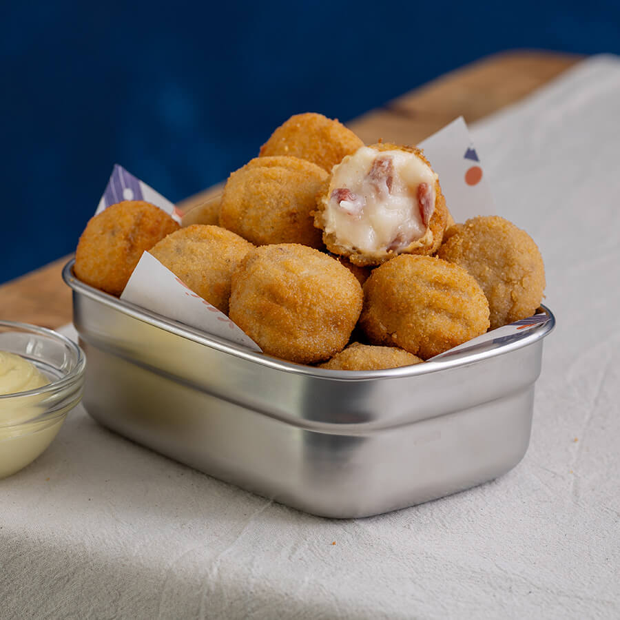 Metallic container filled with fried ham croquetas 
